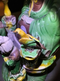 A Chinese verte biscuit group of Guanyin on a lotus throne, 18th C.