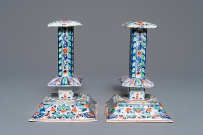 A pair of clobbered Chinese blue and white candlesticks, Kangxi