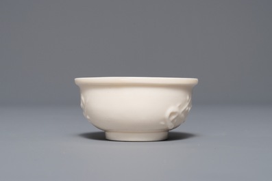 A Chinese Dehua blanc de Chine cup with applied design, seal mark, Kangxi