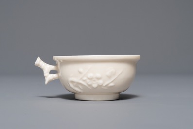 A Chinese Dehua blanc de Chine cup with applied design, seal mark, Kangxi