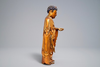 A Chinese carved gilt wood figure of Buddha standing, 18/19th C.