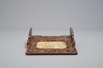 A small Chinese jade plaque mounted in a carved wood table screen, 19/20th C.