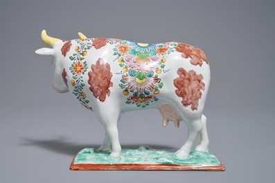 A polychrome Dutch Delft petit feu cow on base, 18th C.