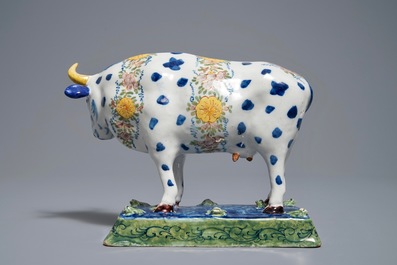 A polychrome Dutch Delft cow on a base with frogs, 18th C.