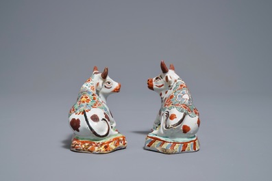 A pair of polychrome Dutch Delft petit feu cows on bases, 18th C.