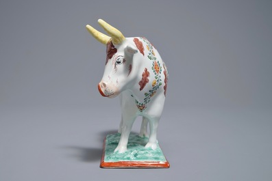 A polychrome Dutch Delft petit feu cow on base, 18th C.