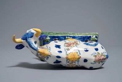A polychrome Dutch Delft cow on a base with frogs, 18th C.