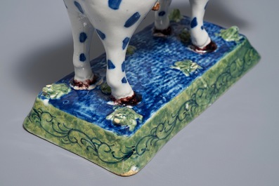 A polychrome Dutch Delft cow on a base with frogs, 18th C.
