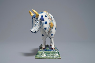 A polychrome Dutch Delft cow on a base with frogs, 18th C.