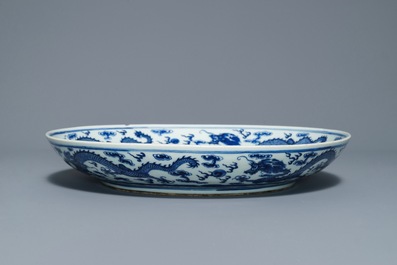Un plat en porcelaine de Chine bleu et blanc &agrave; d&eacute;cor de dragons, marque de Qianlong, 19&egrave;me