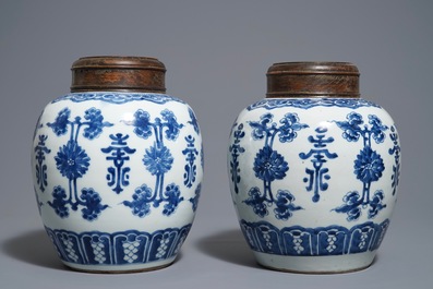 Une paire de pots en porcelaine de Chine bleu et blanc aux couvercles en bois, 18/19&egrave;me