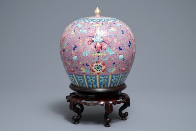 A Chinese famille rose jar and cover on wooden stand, 19th C.