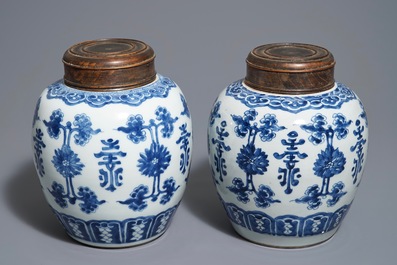 Une paire de pots en porcelaine de Chine bleu et blanc aux couvercles en bois, 18/19&egrave;me