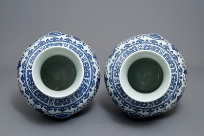 A pair of Chinese blue, white and iron red hu vases with taoist symbols, Qianlong mark, 20th C.