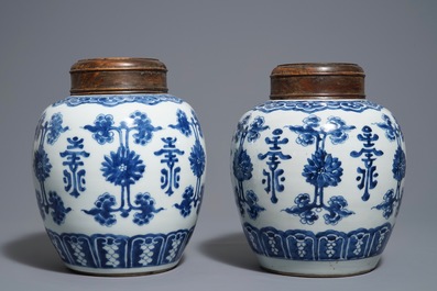 Une paire de pots en porcelaine de Chine bleu et blanc aux couvercles en bois, 18/19&egrave;me