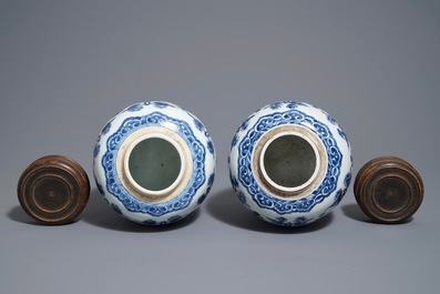Une paire de pots en porcelaine de Chine bleu et blanc aux couvercles en bois, 18/19&egrave;me
