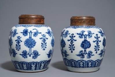 Une paire de pots en porcelaine de Chine bleu et blanc aux couvercles en bois, 18/19&egrave;me