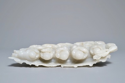 A Chinese white jade group with boys on a raft on carved wooden base, Qing