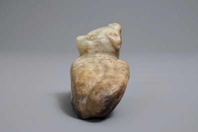 A Chinese pale greenish-grey and brown jade model of a mythical beast, Qing