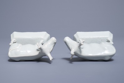 A pair of white Dutch Delft models of cows on bases, 18th C.