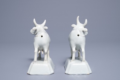 A pair of white Dutch Delft models of cows on bases, 18th C.