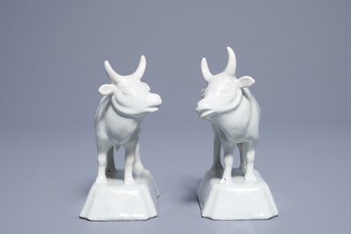 A pair of white Dutch Delft models of cows on bases, 18th C.