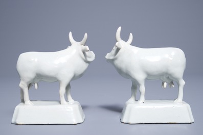 A pair of white Dutch Delft models of cows on bases, 18th C.