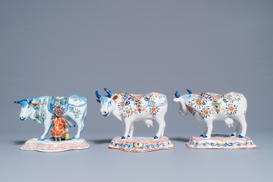 A pair of polychrome Dutch Delft models of cows and one with a milker, 19th C.