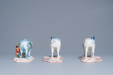 A pair of polychrome Dutch Delft models of cows and one with a milker, 19th C.