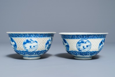 A pair of Chinese blue and white reticulated bowls with landscape panels, Transitional period
