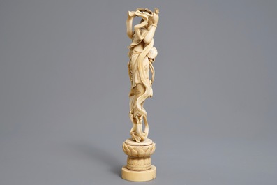A Japanese carved ivory figure of a lady with a drum on a lotus throne, Meiji, 19th C.
