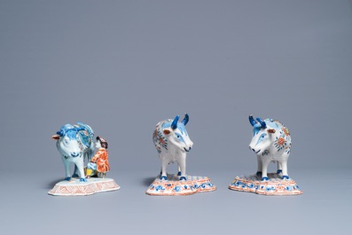 A pair of polychrome Dutch Delft models of cows and one with a milker, 19th C.