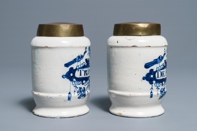 Une paire de pots de pharmacie en fa&iuml;ence de Delft bleu et blanc aux couvercles en laiton, 18&egrave;me