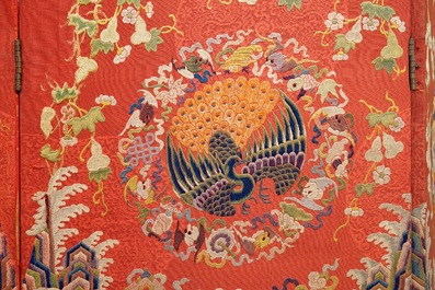 Een Chinees kamerscherm van geborduurde zijde met feniksen op een rode fondkleur, Qianlong