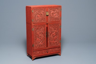 A Chinese cinnabar 'dragons and phoenixes' lacquer cabinet, 19th C.