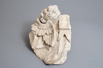 A carved stone wall fragment of a cherub's head with wing, 17/18th C.