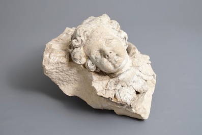 A carved stone wall fragment of a cherub's head with wing, 17/18th C.