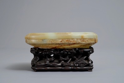 Een Chinese celadon en roest jade dekseldoos op houten sokkel, Ming/Qing