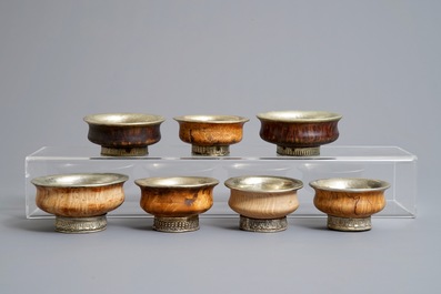 Seven burl wood and silver teabowls and two gilt wood encased Buddhist scriptures, Tibet, 19/20th C.