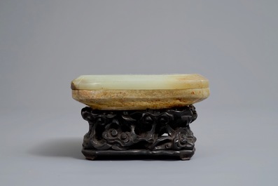 A Chinese celadon and russet jade box and cover on wooden stand, Ming/Qing
