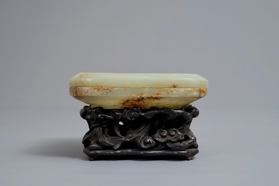Een Chinese celadon en roest jade dekseldoos op houten sokkel, Ming/Qing