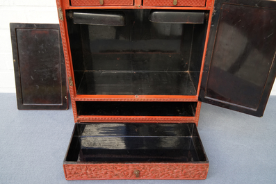 A Chinese cinnabar 'dragons and phoenixes' lacquer cabinet, 19th C.