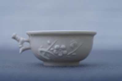 A Chinese Dehua blanc de Chine cup with applied design, seal mark, Kangxi