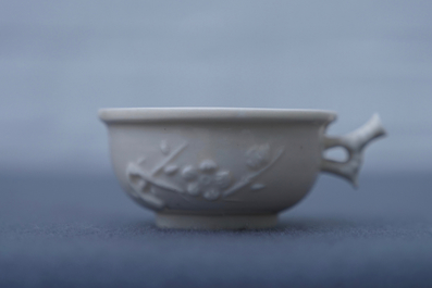 A Chinese Dehua blanc de Chine cup with applied design, seal mark, Kangxi