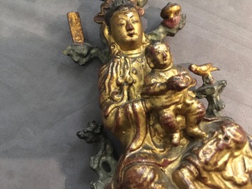 A Chinese gilt-lacquered bronze group of Guanyin with a child, 18th C.