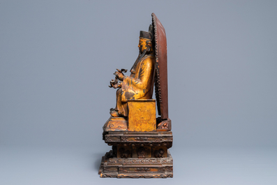 A large Chinese gilt-laquered and inlaid bronze figure of Zhenwu on gilt wooden base, Ming