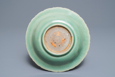 Een Chinees Longquan celadon bord met onderglazuur pioendecor, Ming