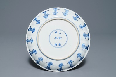 Une assiette en forme de lotus en porcelaine de Chine bleu et blanc, marque et &eacute;poque de Kangxi