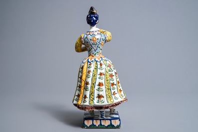 A large polychrome Dutch Delft model of a lady with a dog, 18th C.