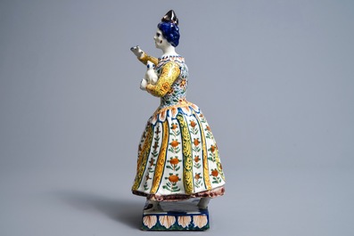 A large polychrome Dutch Delft model of a lady with a dog, 18th C.